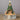 Decorative nativity scene with a Christmas tree and star on top, set against a dark background.
