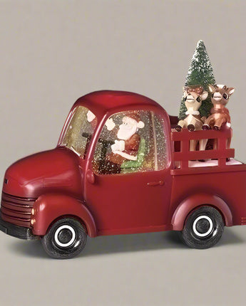 Red toy truck with Santa Claus and reindeer on a dark background