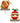 Two Christmas tree topper ornaments displayed on black-and-white striped stands against a white background. One ornament is a red ball with green stripes and holly motifs, and the other is a red ball with a cream band, green holly leaves, red berries, and a green bow.