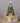 Decorative nativity scene with a Christmas tree and star on top, set against a dark background.